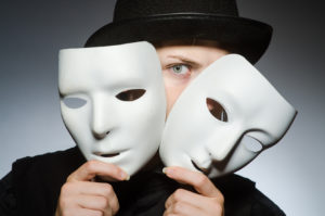 Artiste cachant son visage entre 2 masques