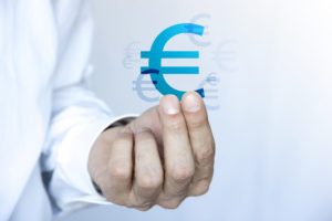 Gros plan sur une main tenant le signe euro