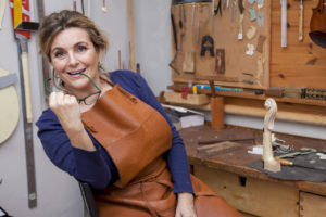 Luthière devant son atelier.