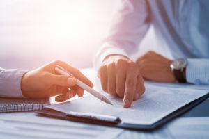 Cadrage sur les mains de deux personne en chemise discutant d'un contrat.