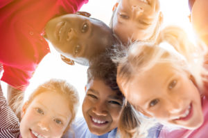 Photo d'un groupe d'enfants en cercle, photographié par en dessous.